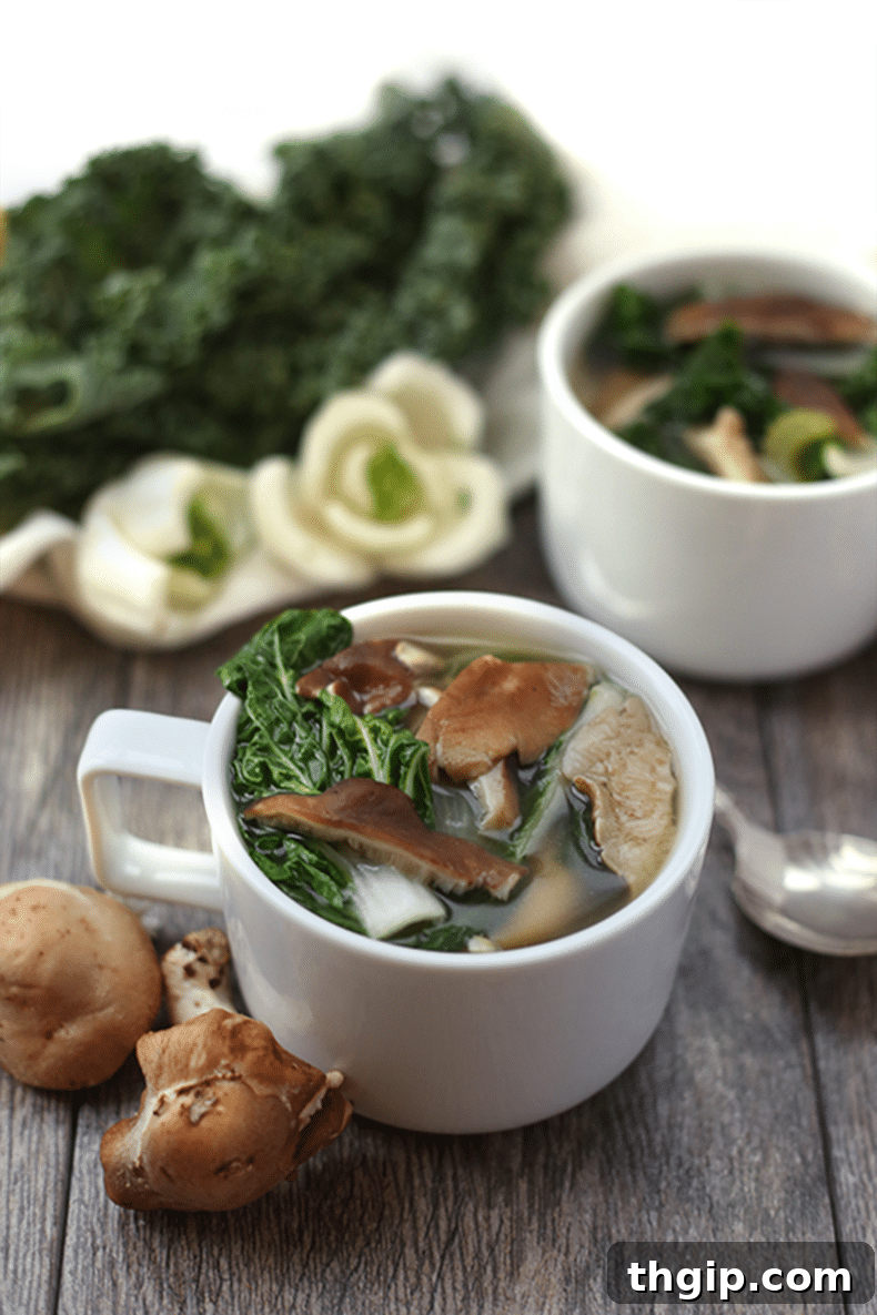 Potent Immunity Broth 2 A bowl of vibrant, steaming immune-boosting soup, garnished with fresh herbs and served on a rustic wooden surface.