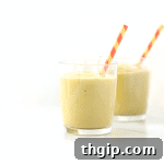 Delicious and creamy Post-Workout Recovery Smoothie in a glass, with fresh ingredients like avocado, pineapple, and banana scattered around, perfect for recovery.