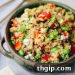 A colorful bowl of Harvest Grain Salad with quinoa, vegetables, dried fruit, and nuts.