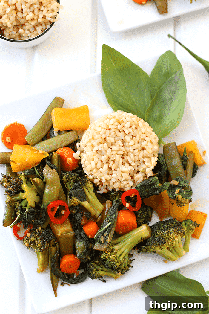 A colorful plate of Easy Thai Basil Vegetable Stir Fry with brown rice, garnished with fresh basil leaves. Perfect for a quick and healthy weeknight dinner.
