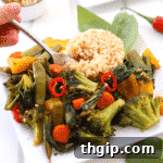 Plate with thai basil vegetable stir fry and brown rice. Fork taking a bite of rice and vegetables.
