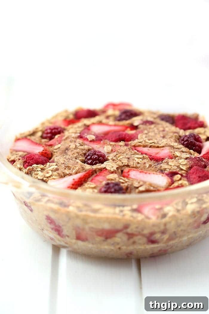 Berry Burst Baked Oatmeal 3 A close-up shot of the Triple Berry Baked Oatmeal in a baking dish, ready to be served, highlighting its rich texture and berry inclusions. A perfect gluten-free and vegan dish.