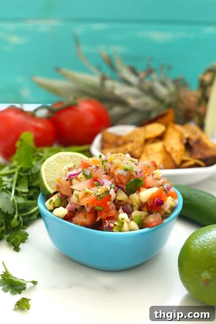 A bowl of vibrant homemade sweet and spicy pineapple salsa, garnished with fresh cilantro, ready to be served.