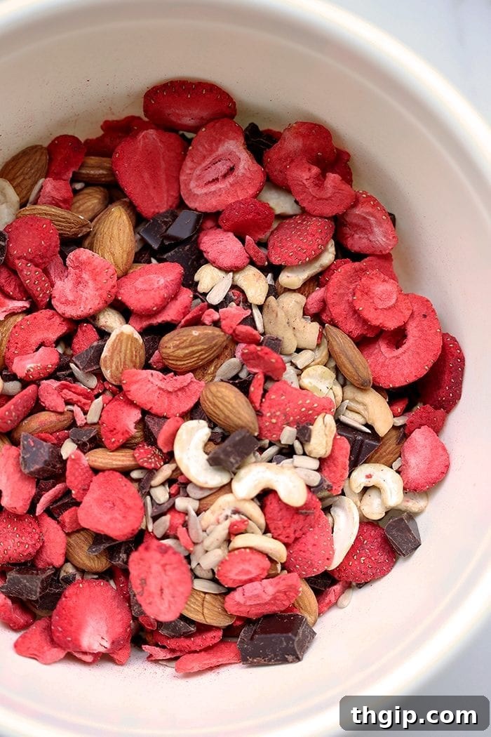 Crimson Cocoa Trail Mix 3 Mixing bowl of trail mix made of mixed nuts, seeds, freeze dried strawberries and chocolate chunks.
