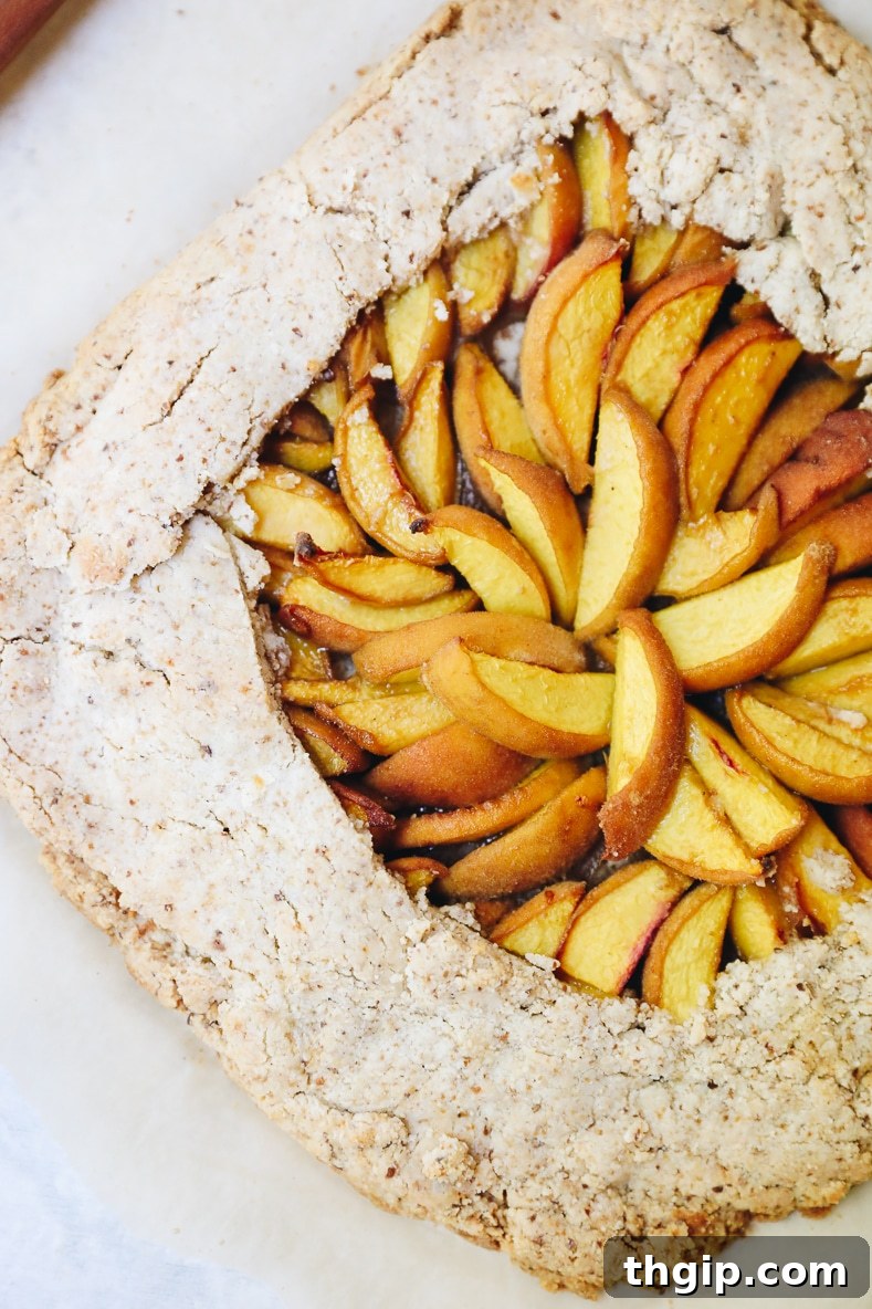Rustic Vegan Peach Galette 7 A freshly baked vegan peach galette, golden brown and glistening with juicy peaches, cooling on a rack.