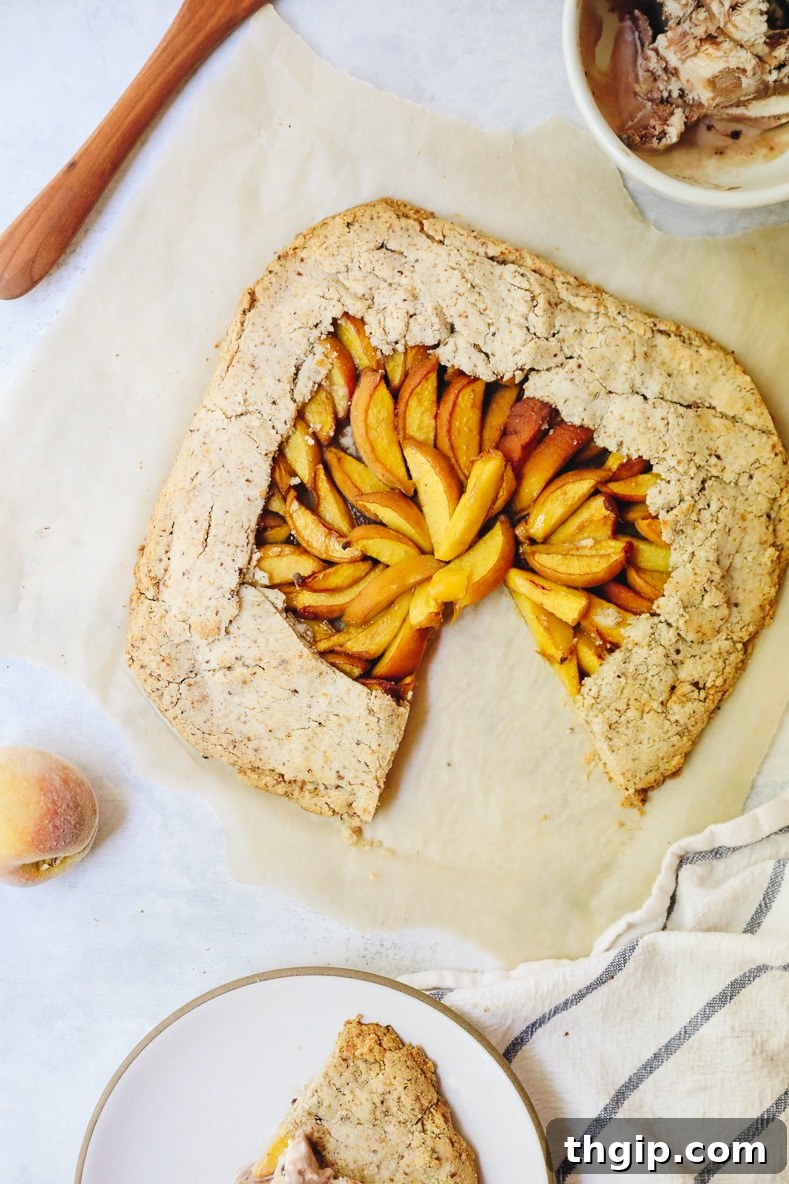 Rustic Vegan Peach Galette 8 A slice of vegan peach galette with a scoop of dairy-free ice cream, ready to be enjoyed.