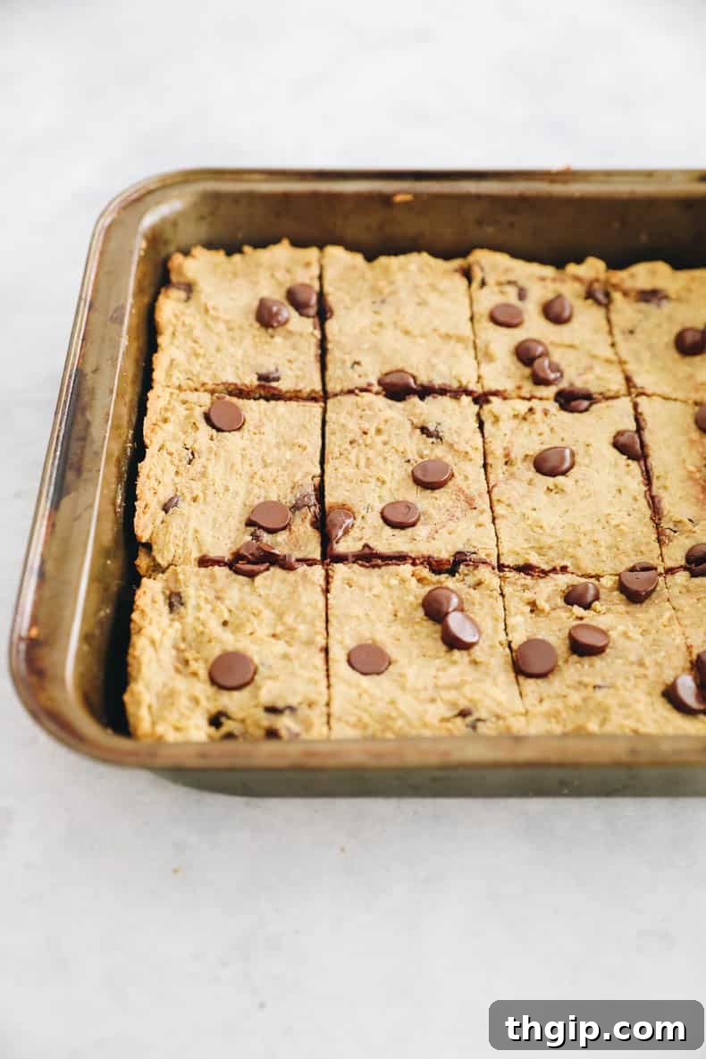 Wholesome Chickpea Blondies 7 Freshly baked chickpea blondies, perfectly cut into squares and arranged in a baking dish, ready to be enjoyed.