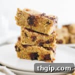 3 chickpea blondies stacked on top of each other on a white plate.