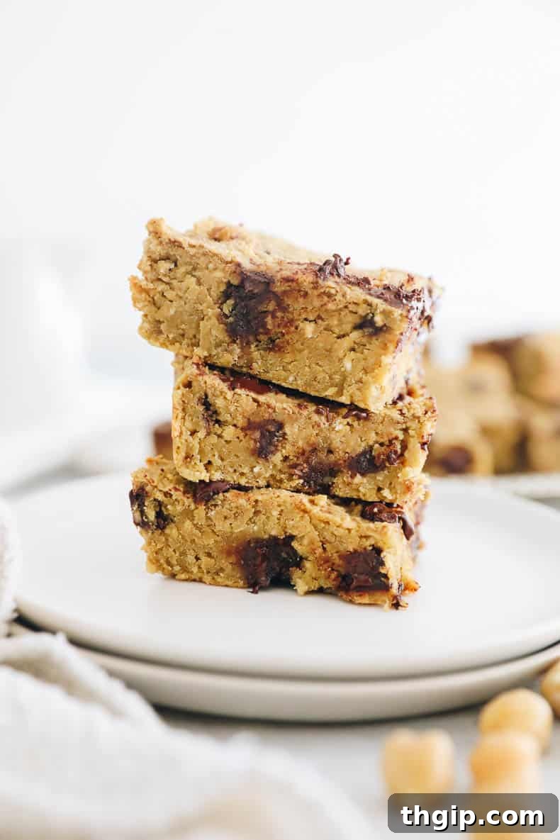 Wholesome Chickpea Blondies 9 A close-up shot of a healthy chickpea blondie, showing its delicious texture and generous chocolate chips, resting on a serving board.