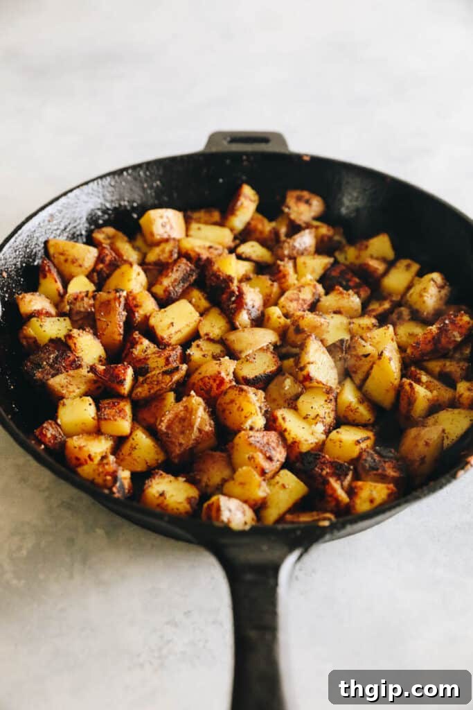 Crispy Roasted Potatoes: Two Mouthwatering Variations 6 Microwaved potatoes being pan-roasted with spices in a cast-iron skillet.