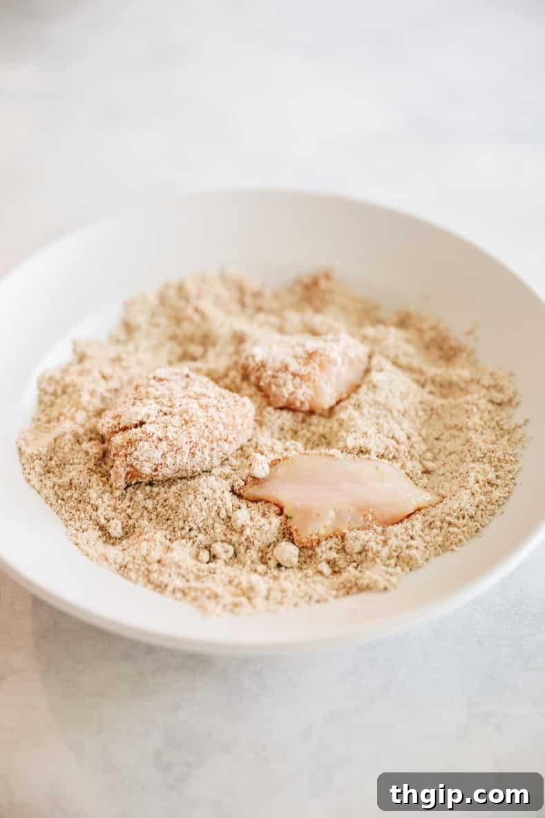 Caramelized Orange Chicken 3 Pieces of raw chicken sitting in a bowl of spices for a coating before baking.
