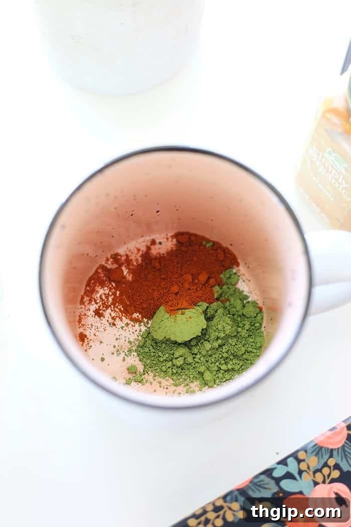 Turmeric Matcha Elixir 3 First step for Matcha Turmeric Latte: Adding matcha powder, turmeric, and a pinch of black pepper to a large mug, ready to be whisked.