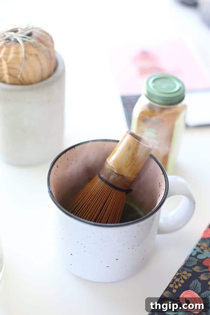 Turmeric Matcha Elixir 4 Second step for Matcha Turmeric Latte: Whisking the matcha, turmeric, and black pepper with hot water until smooth and frothy.