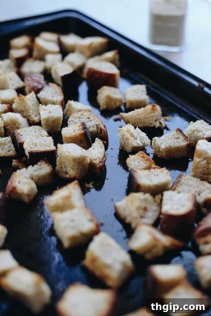 Vibrant Spring Harvest Soup 3 A baking sheet laden with freshly baked golden-brown sourdough croutons, perfectly toasted and ready to top a delicious soup, highlighted against a rustic background.