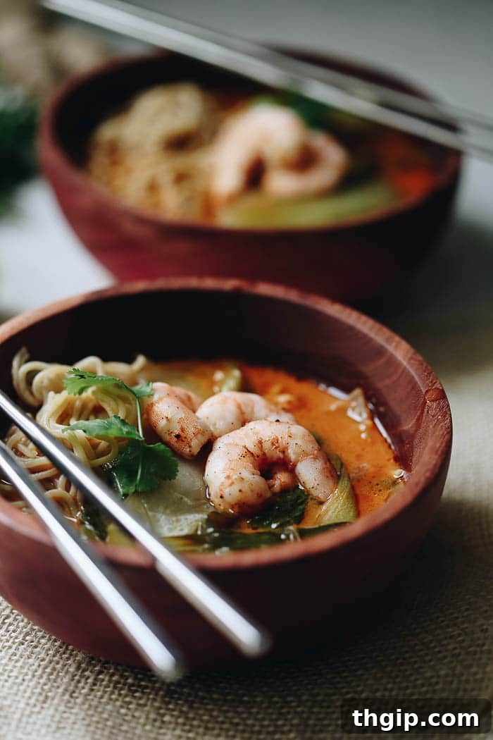 Thai Coconut Curry Shrimp Ramen 3 An overhead shot of a beautifully presented bowl of Curried Thai Coconut Ramen, garnished with fresh herbs, showcasing the rich colors and inviting textures of the dish.