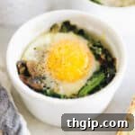 One ramekin with vegetables, baked eggs and spices inside, ready to eat.