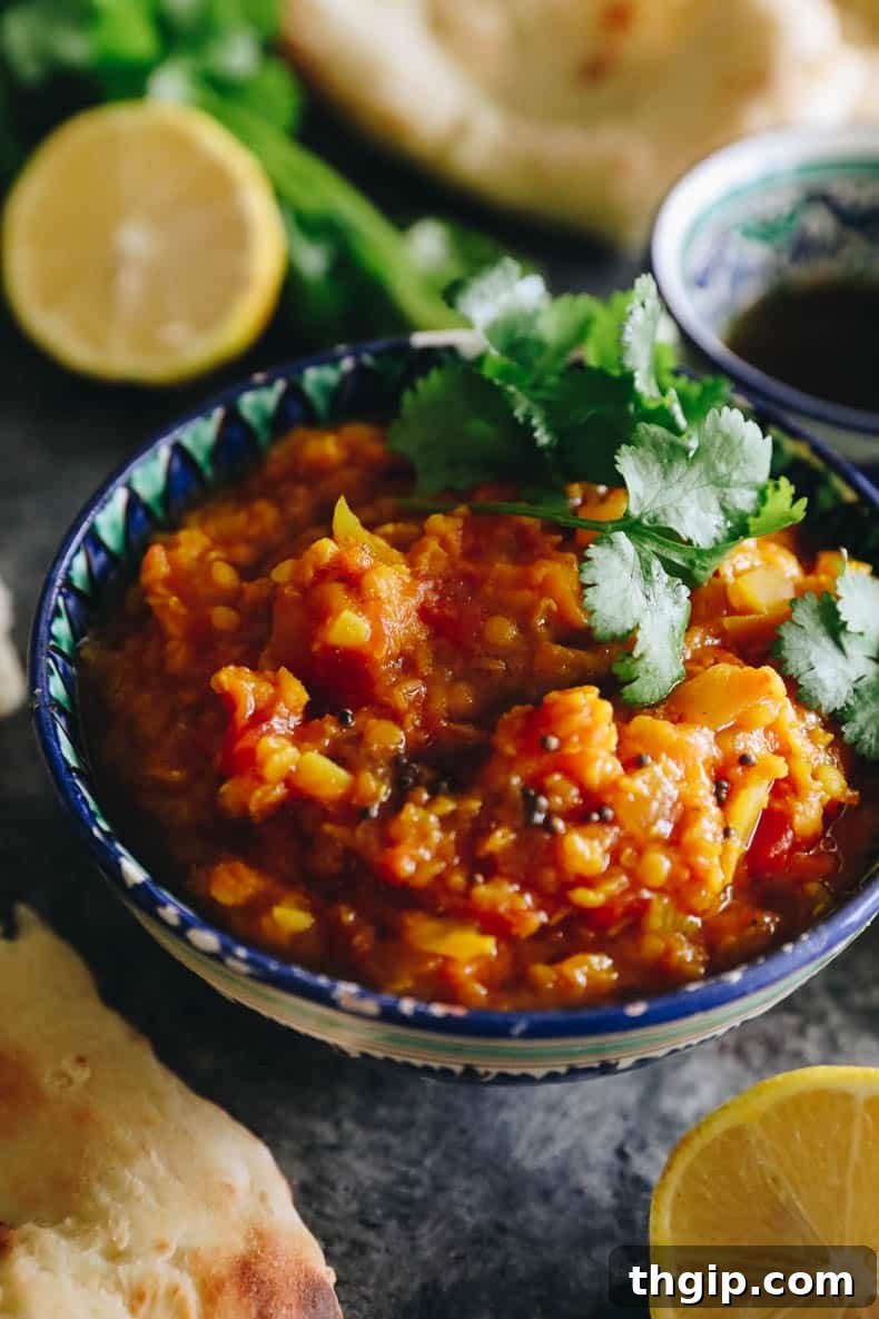 Close-up image of root vegetable dal topped with spice oil and fresh cilantro.