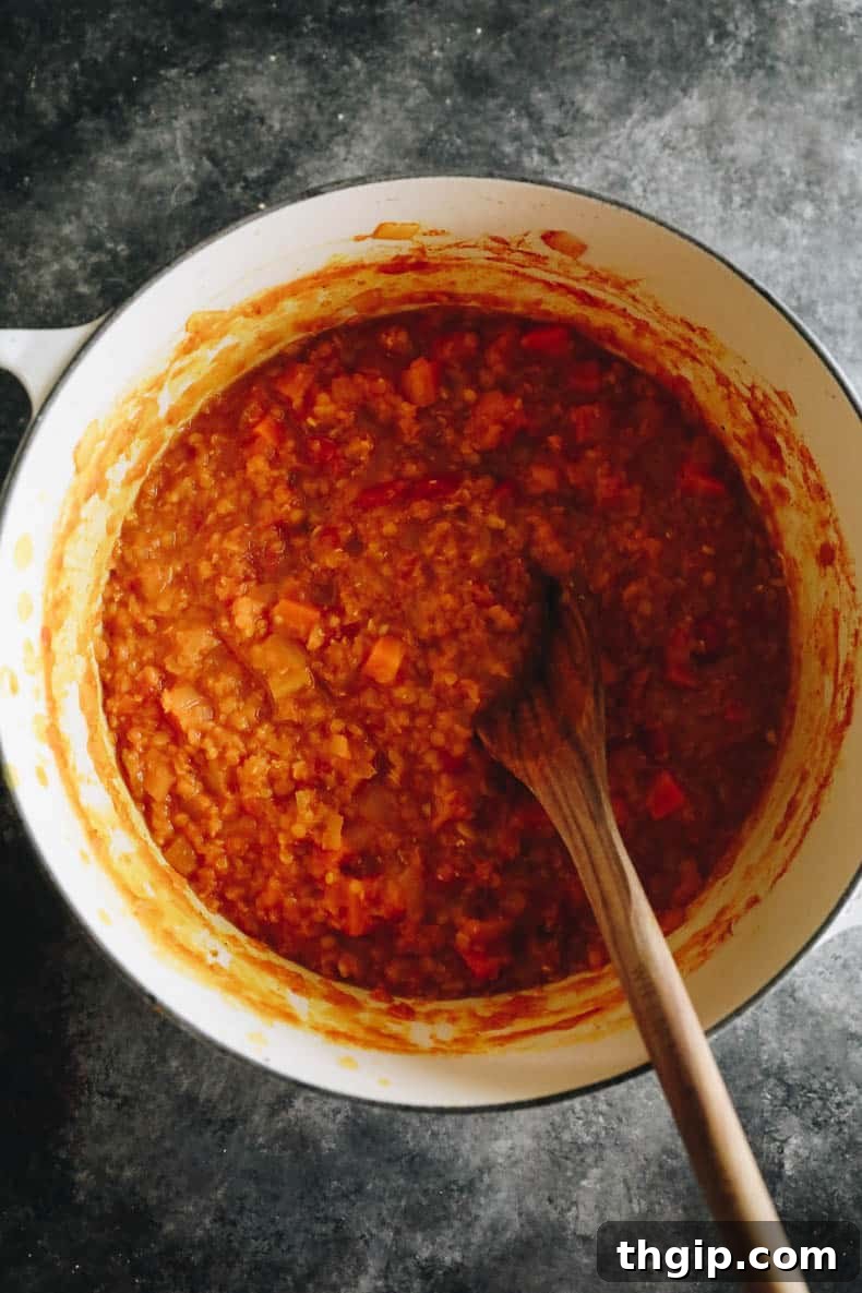 Cooked vegetable dal recipe in a white Dutch oven, steaming gently.