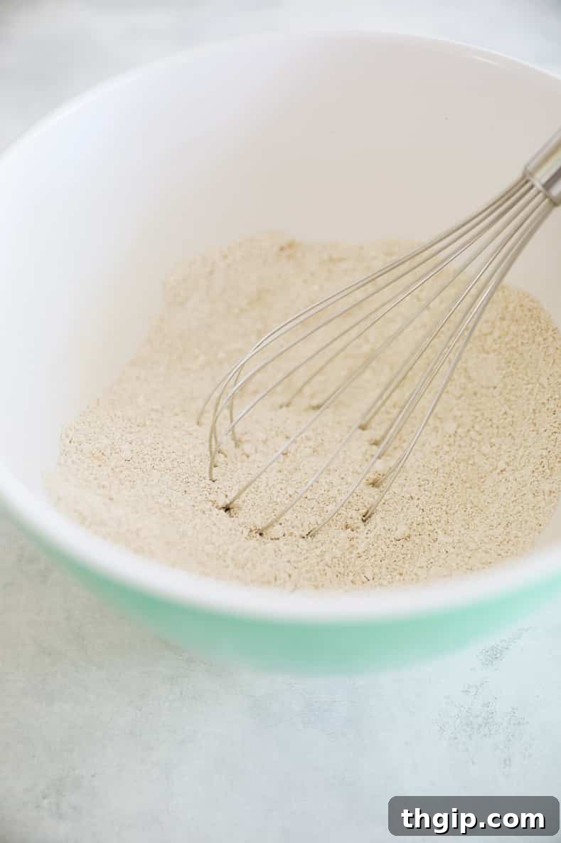 Wholesome Zucchini Banana Bread 4 Dry ingredients like oat flour, cinnamon, nutmeg, baking powder, and sea salt mixed in a large bowl.