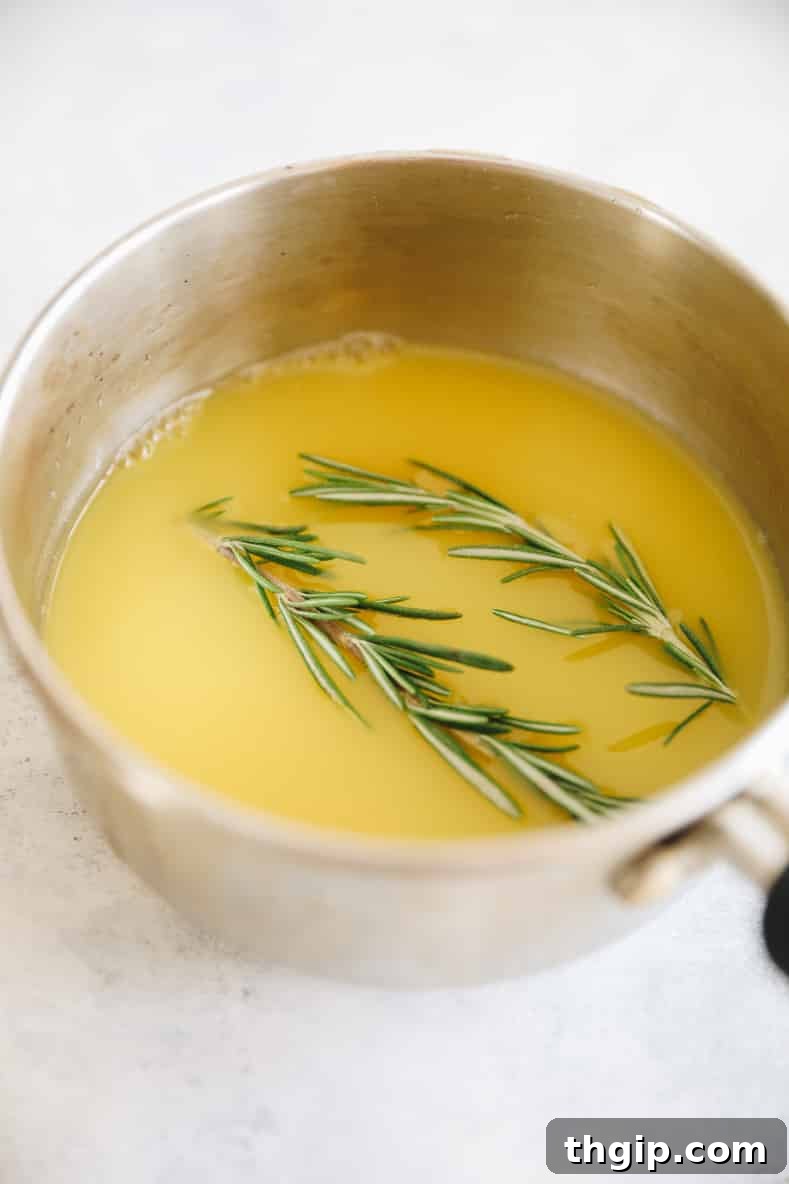 Zesty Orange Rosemary Scones 4 Orange juice and rosemary sprigs boiling in a small pot.