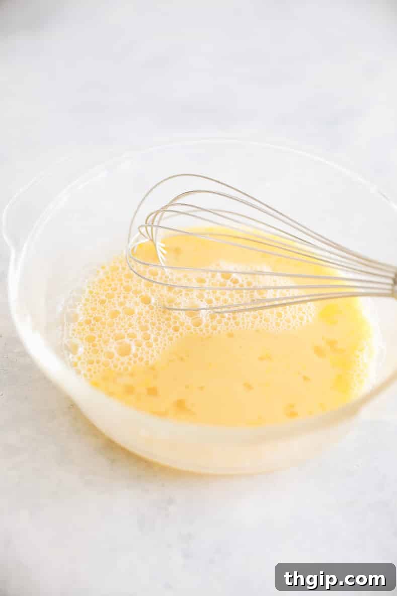 Zesty Orange Rosemary Scones 6 Mixing wet ingredients including orange rosemary juice, maple syrup, milk, and egg.