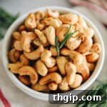 Artisan Rosemary Cashews 3 A white bowl of roasted cashews with rosemary.