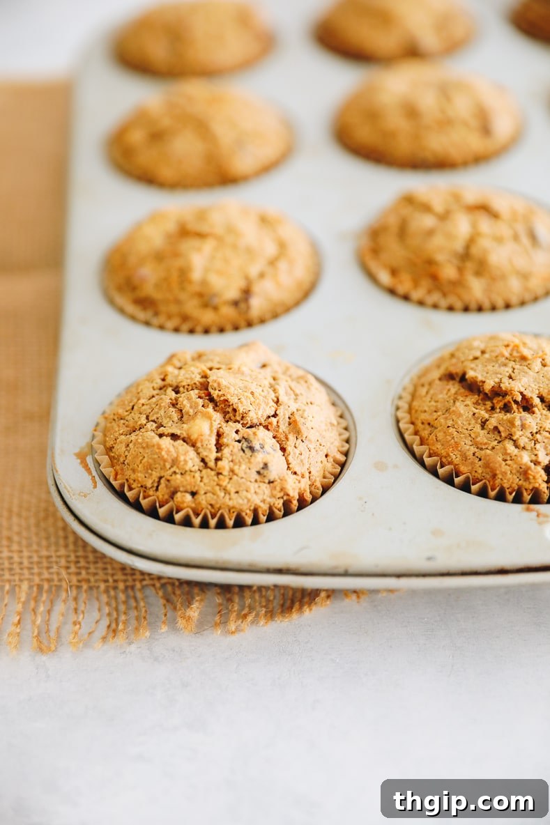 Muffin batter scooped into a lined muffin tray, ready for baking.