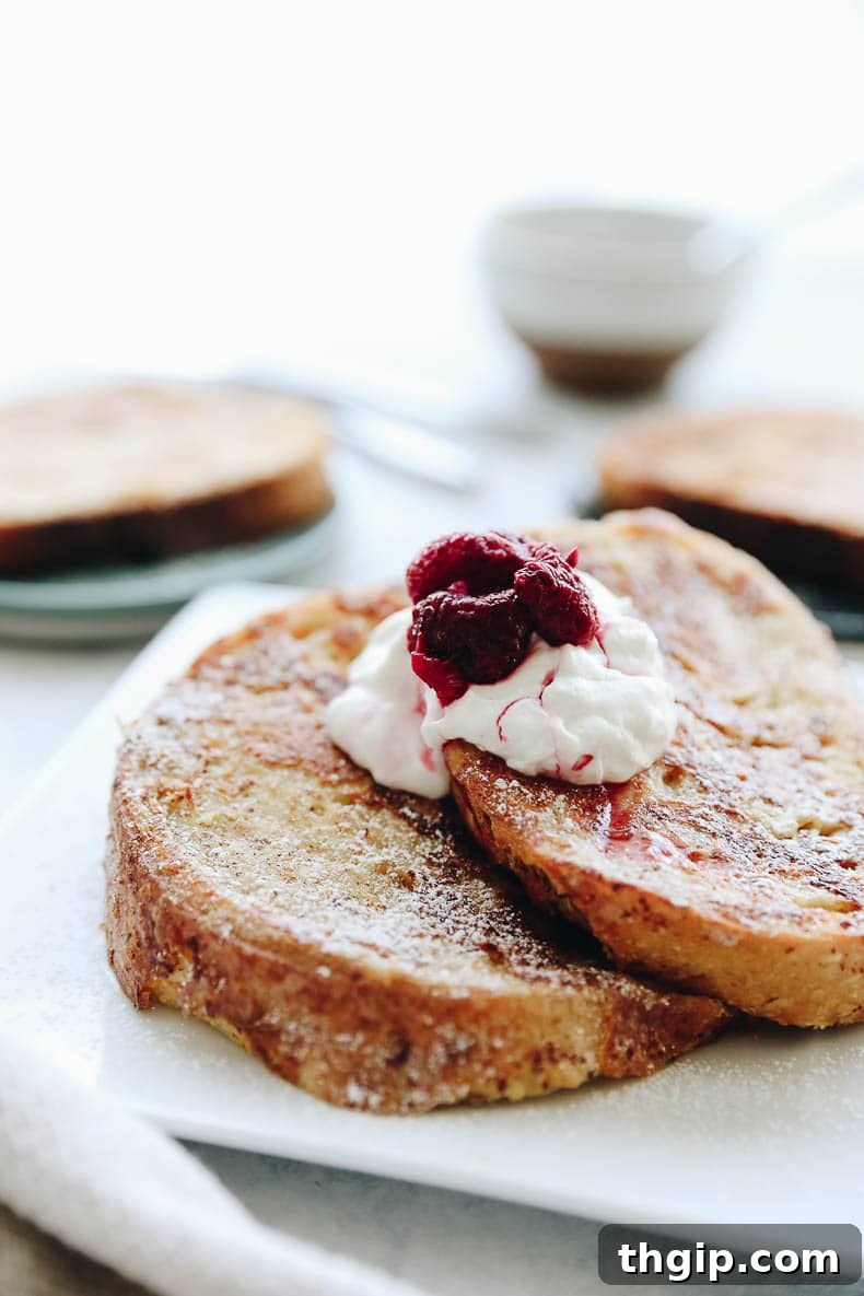 A final shot of healthy French toast stacked on a plate, garnished with berries and maple syrup, ready to be served.
