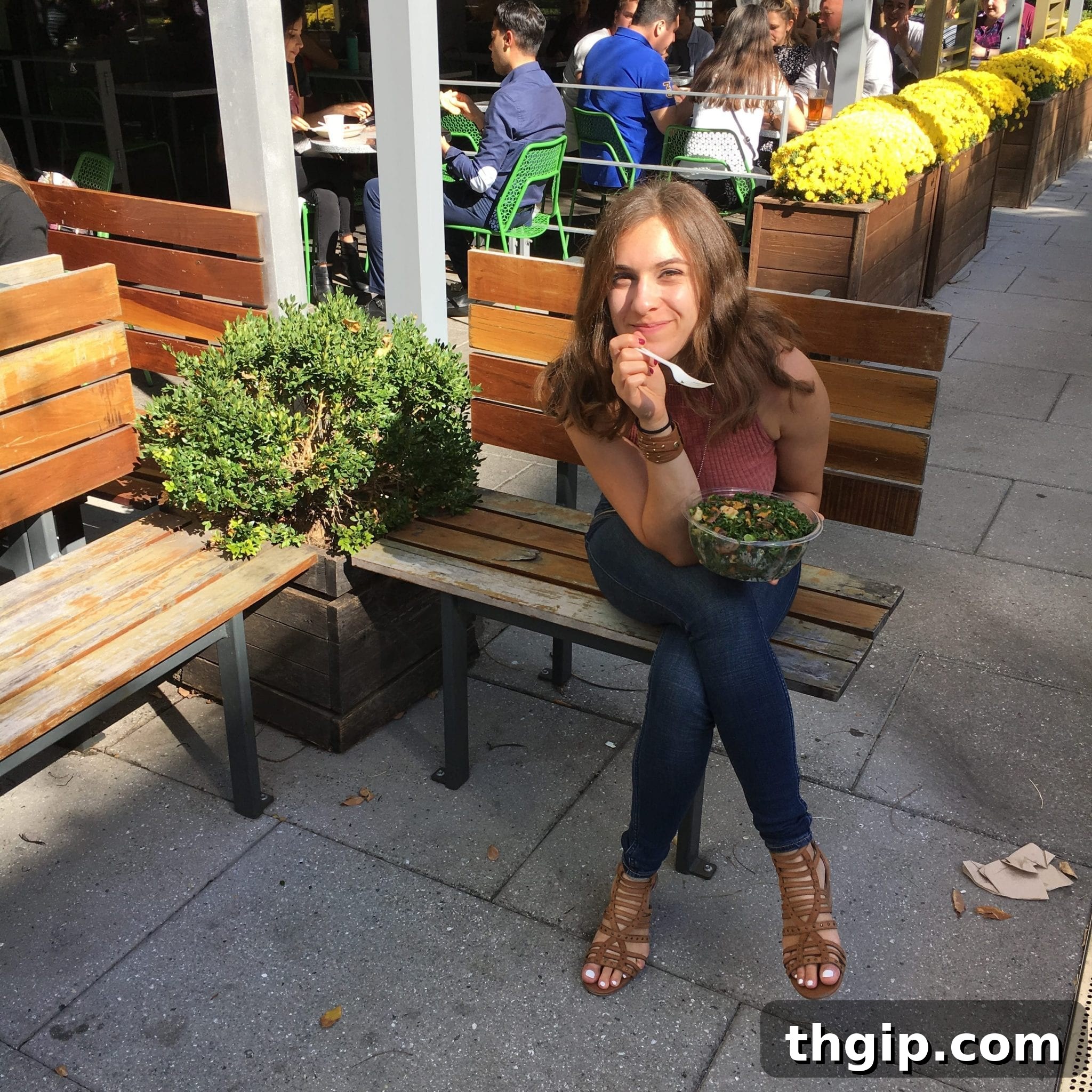 A student writing in a notebook, with a laptop and coffee nearby, in a bright, modern setting.
