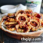 Maple Roasted Squash with creamy Tahini Yogurt Dressing, garnished with pepitas and pomegranate seeds, perfect for a healthy weeknight or Thanksgiving side dish.