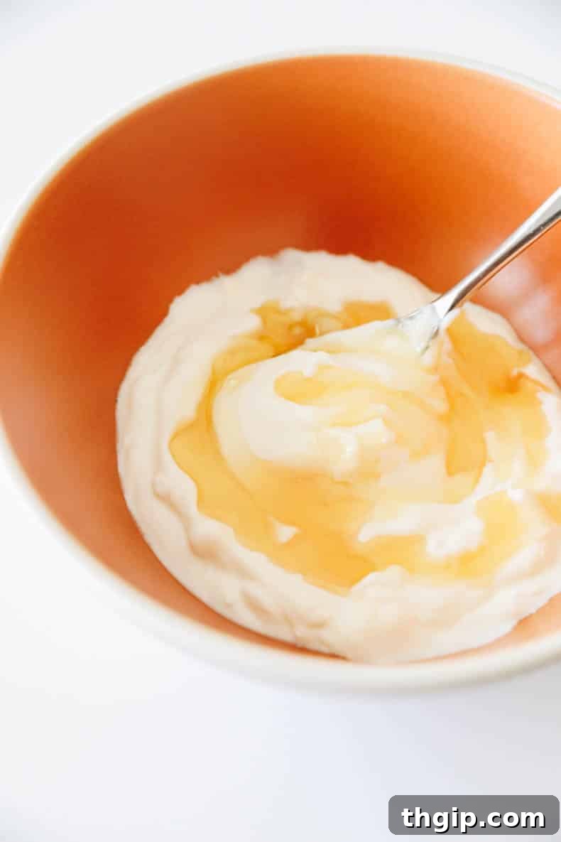Mixing homemade frozen yogurt ingredients in a bowl before churning.