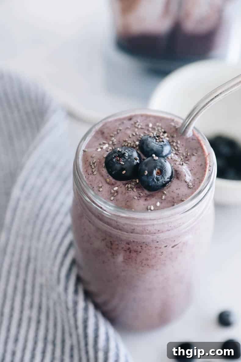 Close-up of a blueberry smoothie in a glass, showcasing its smooth and creamy texture with visible blueberry swirls.