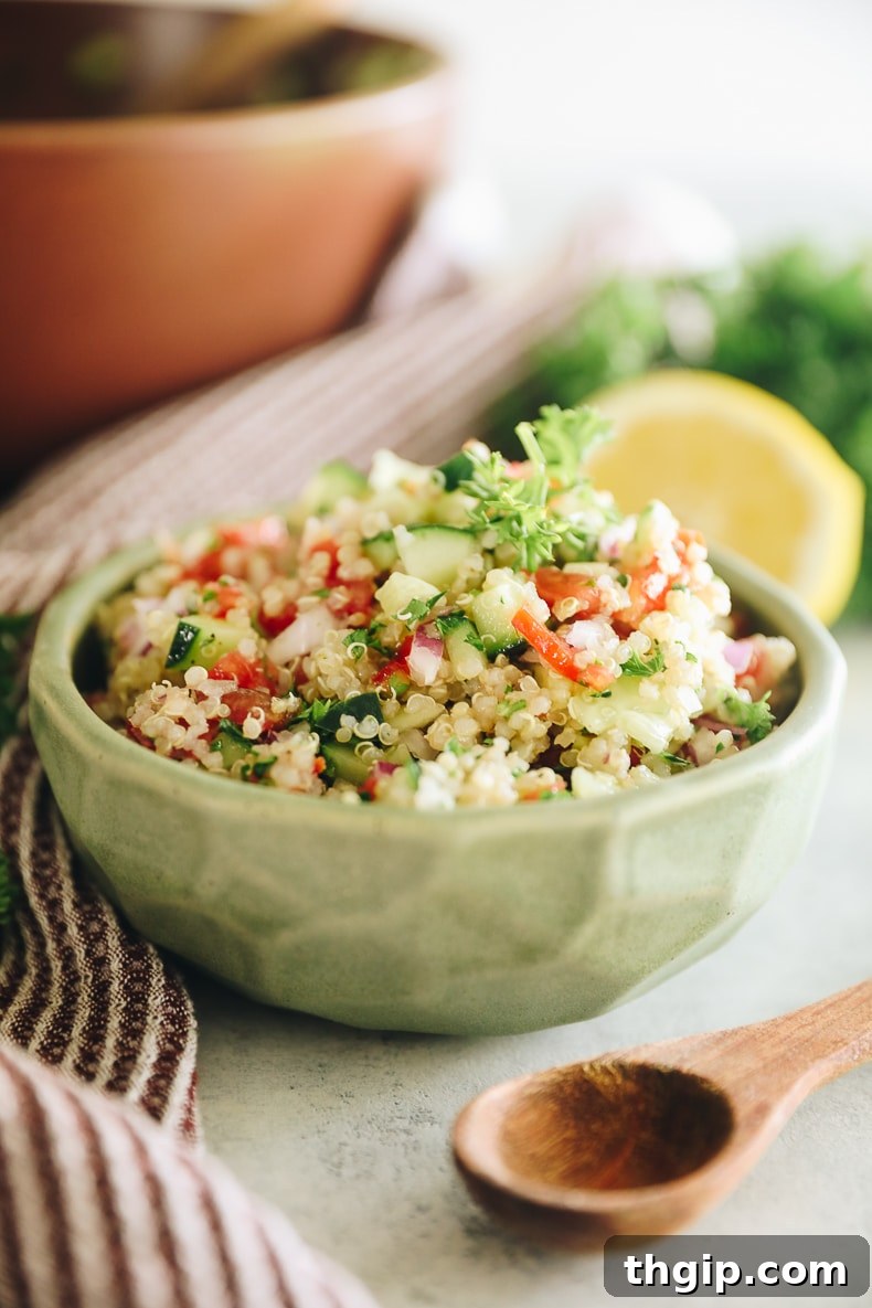 Vibrant Mediterranean Quinoa Salad 2 israeli salad veggies mixed with quinoa in a green bowl