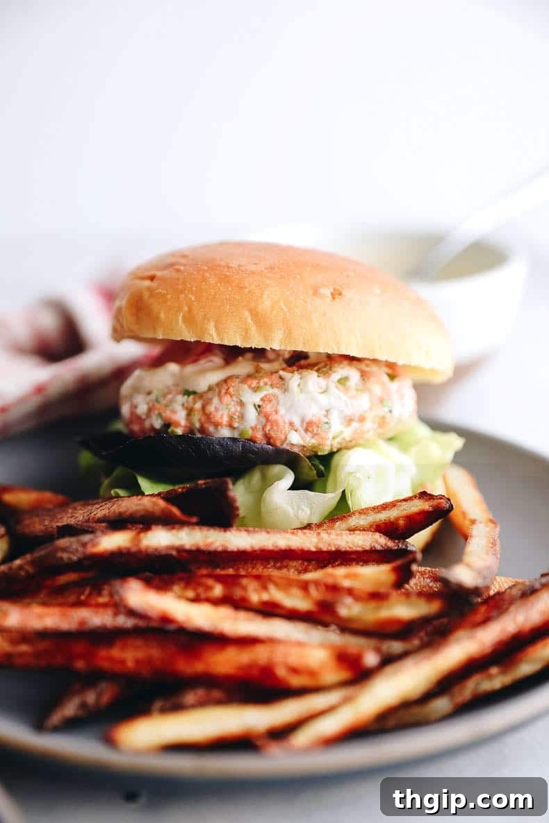 Salmon Burgers: Classic and Creative 2 Salmon burgers in a bun with baked french fries.