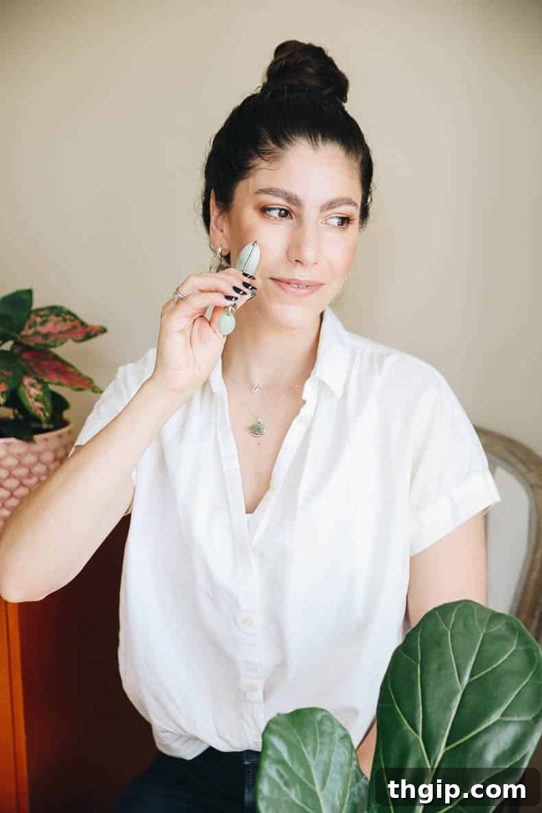 The Jade Roller and Gua Sha Your Path to Radiant Skin 3 woman using a jade roller on her face, demonstrating the correct technique for glowing skin.