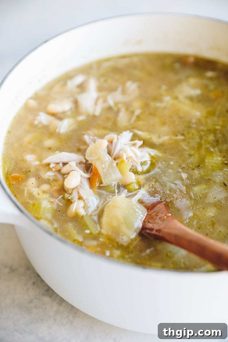 Thanksgiving Revival Soup 5 A large pot of turkey carcass soup simmering on the stove with vegetables and grains.