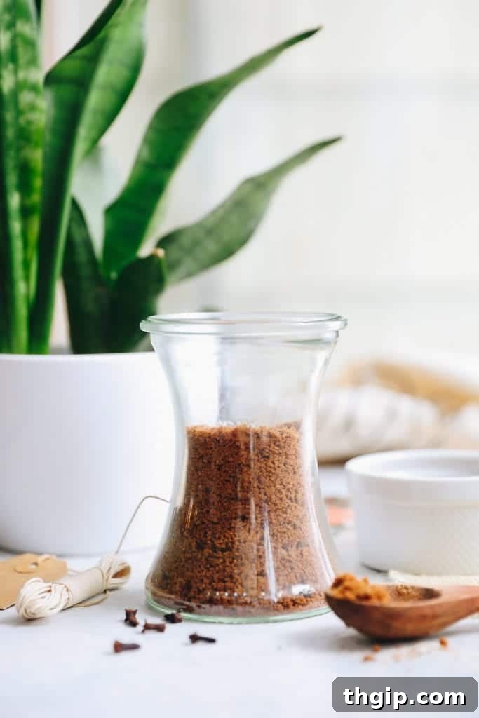 Homemade Gingerbread Sugar Scrub in a glass jar, ready for gifting or personal use, surrounded by festive decor.