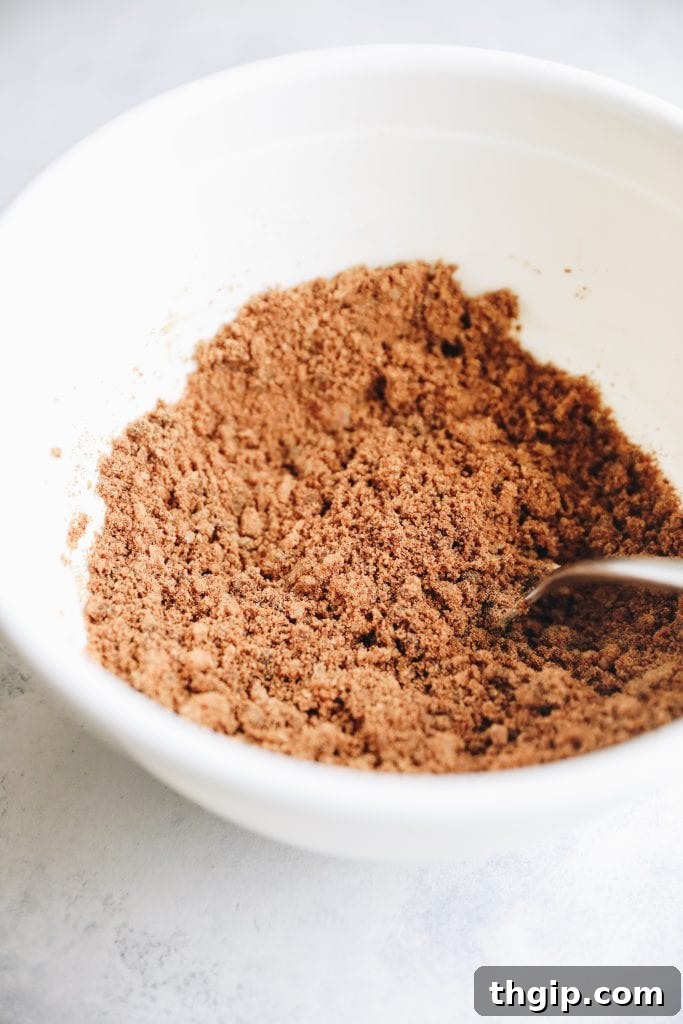 Close-up of the Gingerbread Sugar Scrub texture in a glass jar, highlighting its natural, coarse granules and rich color.