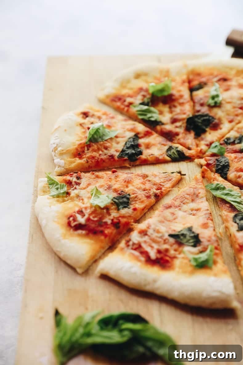 Perfect Homemade Pizza Dough Recipe 3 A freshly baked homemade Margherita pizza, sliced and ready to serve