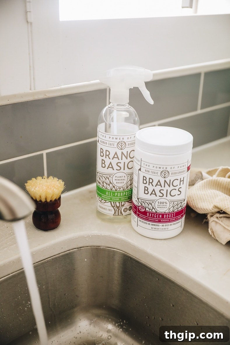 Mastering Your Kitchen Deep Clean 5 A selection of natural cleaning products and tools, including spray bottles, brushes, and sponges, neatly arranged on a clean kitchen counter.