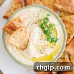 Thumbnail image of creamy homemade hummus in a green bowl.