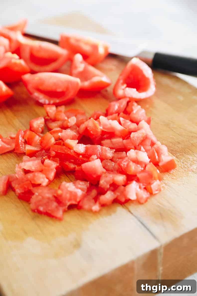 Summer Corn Salsa 3 Freshly chopped tomatoes on a cutting board, ready to be combined with other salsa ingredients.