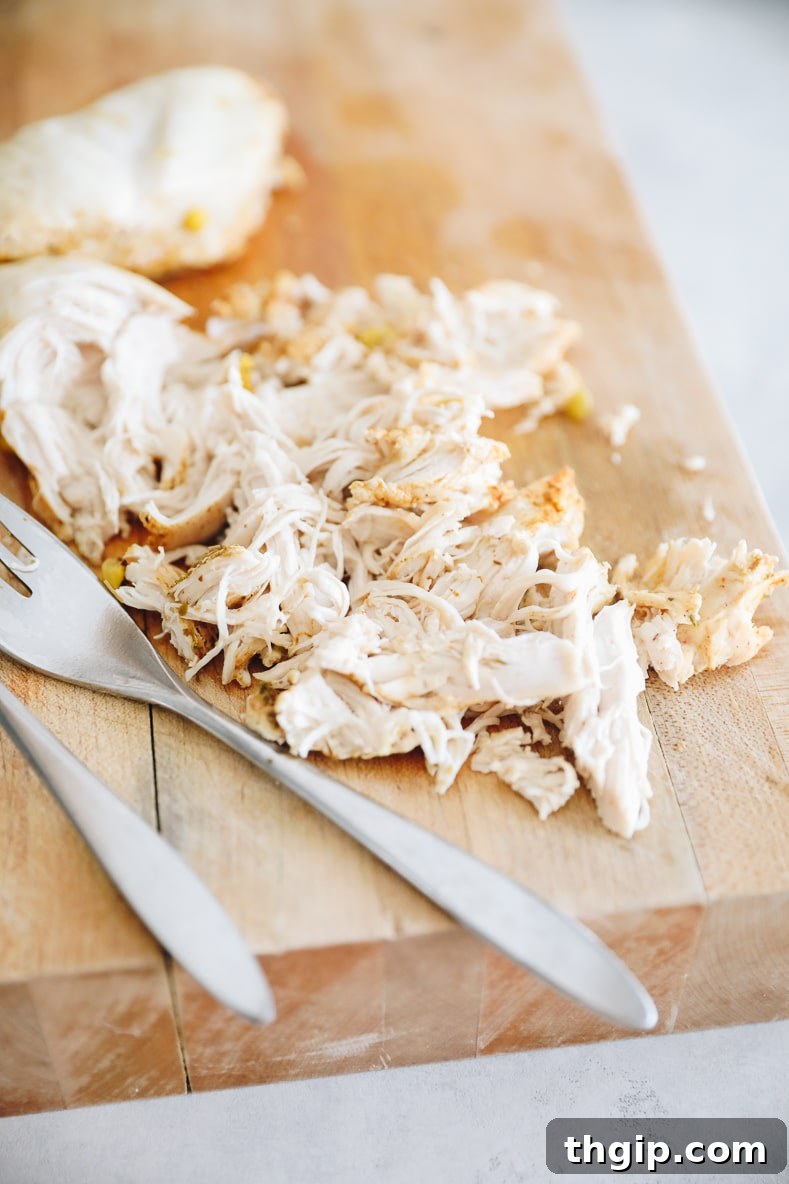 Creamy Instant Pot White Chicken Chili 4 Shredded cooked chicken on a cutting board next to the Instant Pot.