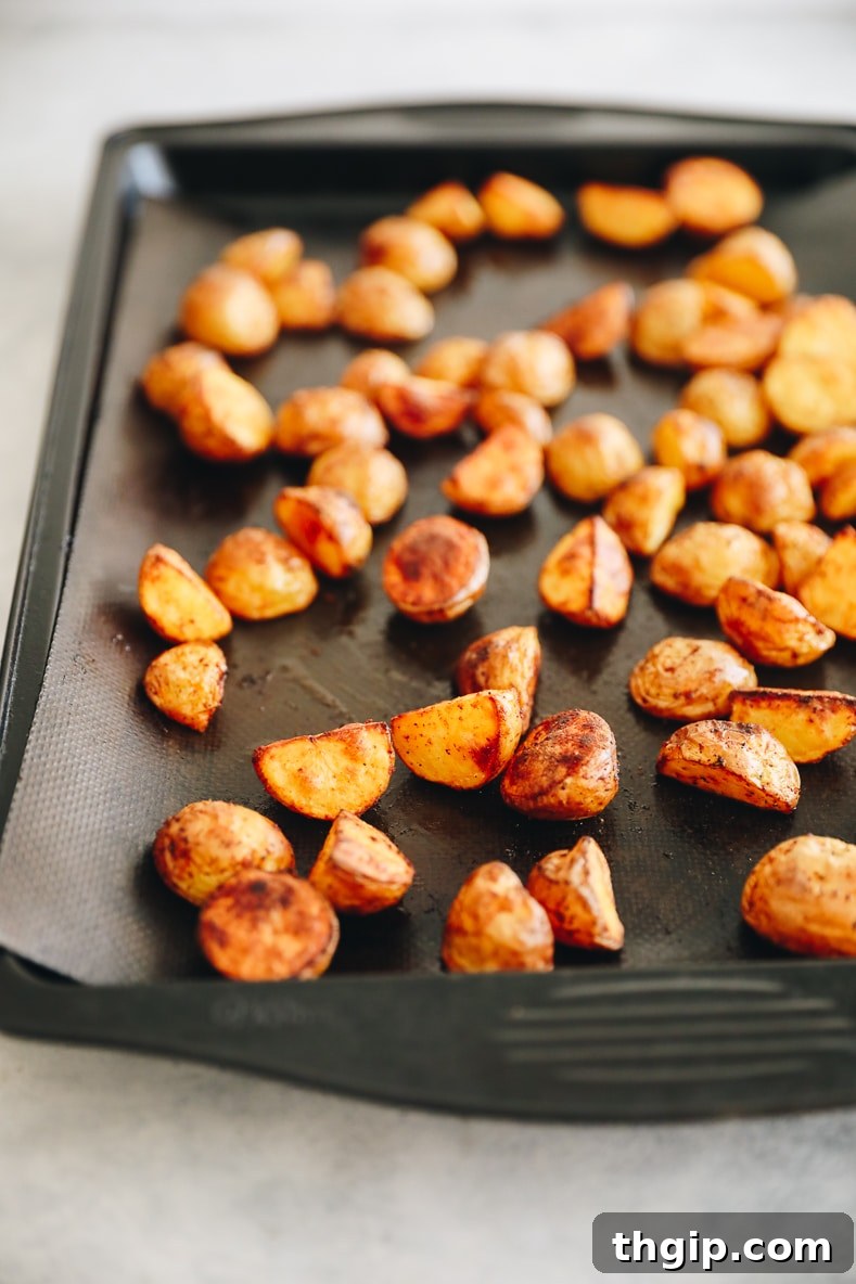 Breakfast Bravas Skillet 4 Crispy baked potatoes spread on a parchment-lined baking sheet, golden and ready.