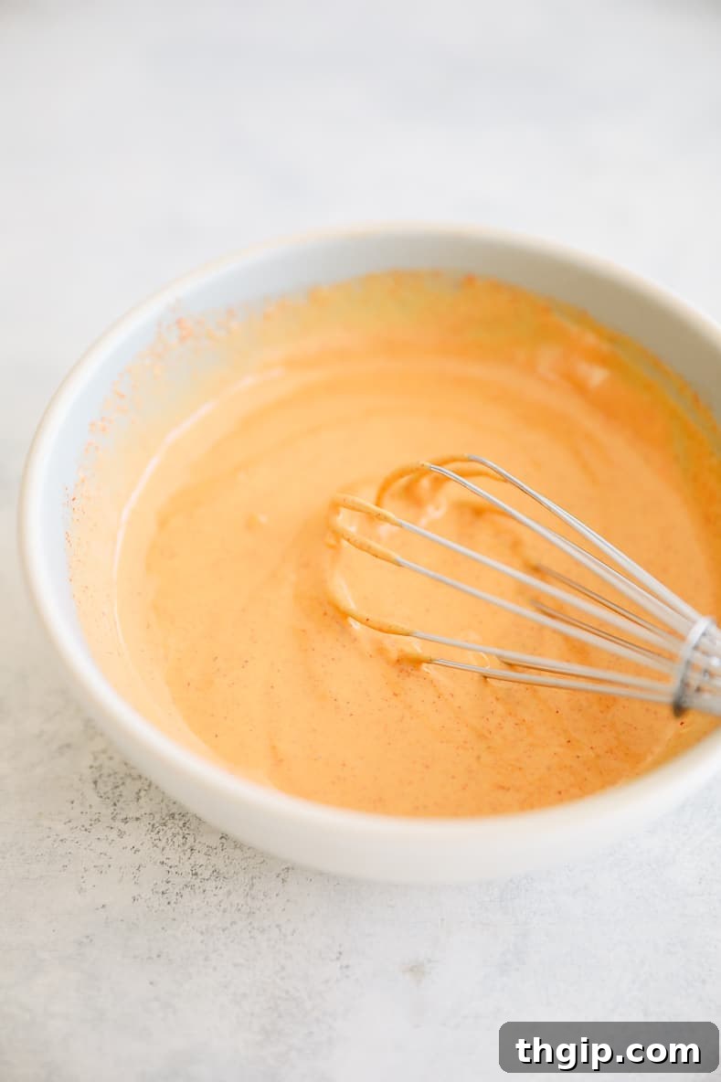 Breakfast Bravas Skillet 5 Ingredients for chipotle garlic aioli – mayo, red wine vinegar, garlic, hot sauce, and paprika – in a bowl with a whisk.