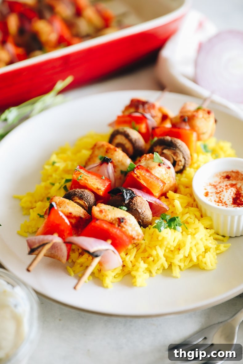 Golden Oven-Baked Chicken Skewers 2 Oven-baked chicken kabobs on a skewer, garnished with fresh parsley.