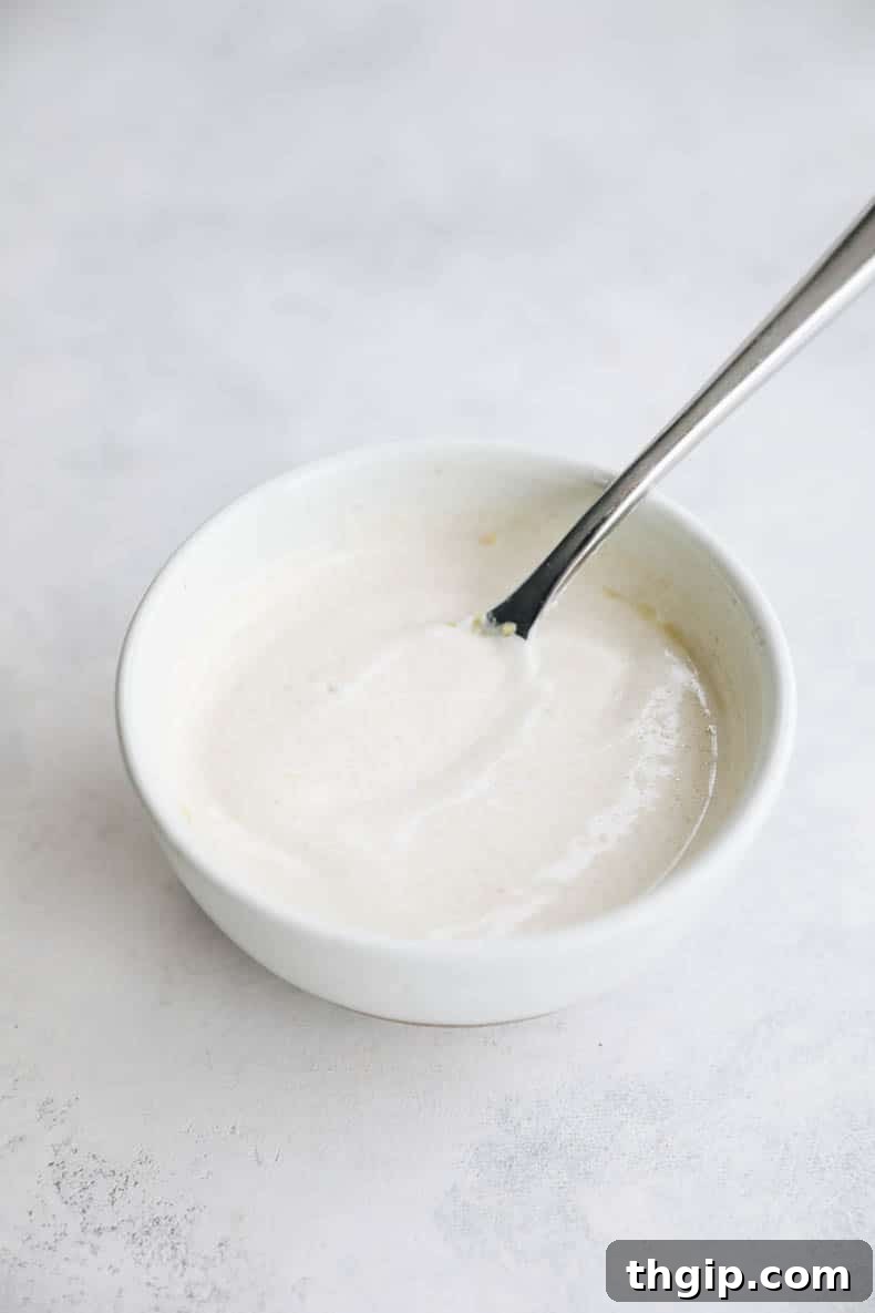 Golden Oven-Baked Chicken Skewers 4 Tangy lemon yogurt sauce in a small white bowl.
