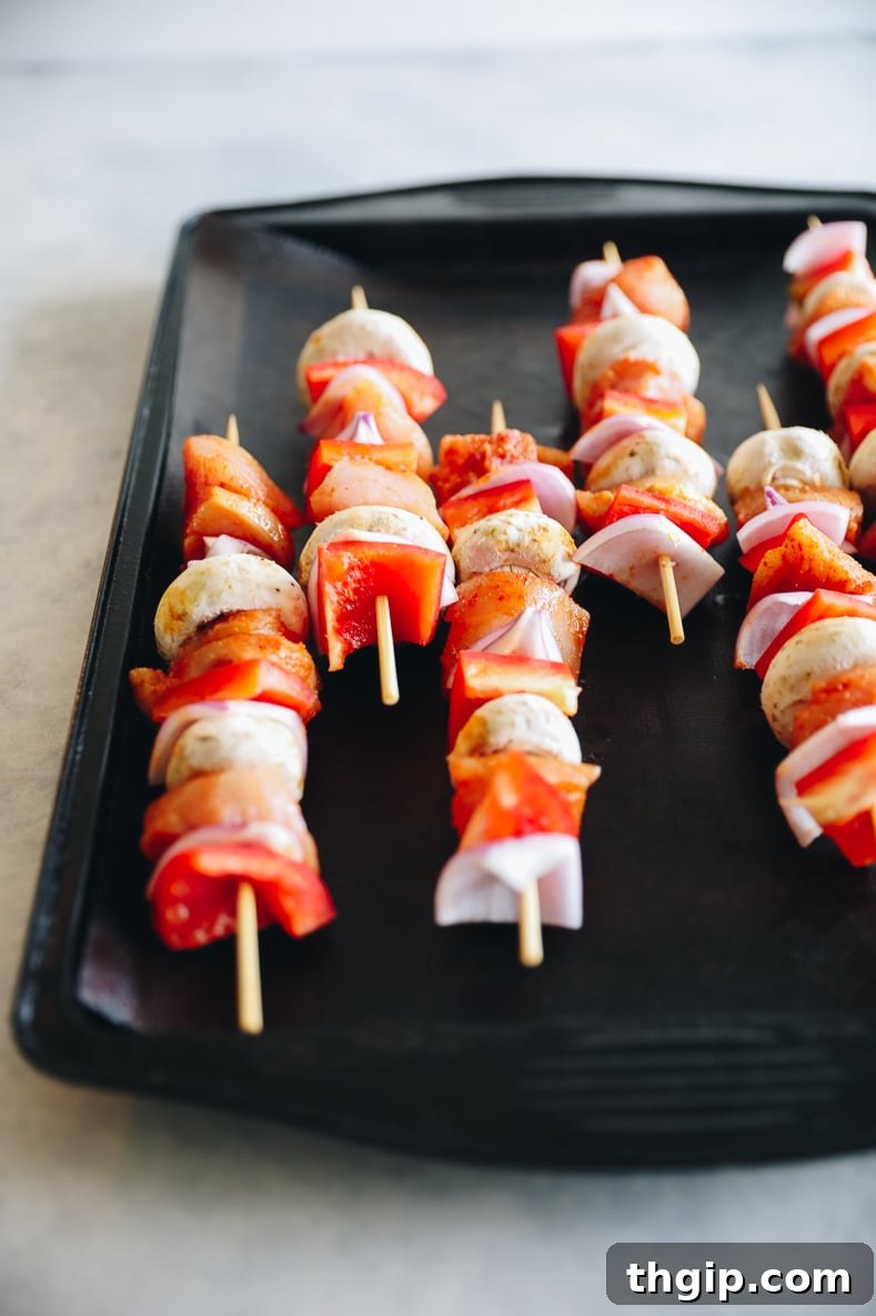 Golden Oven-Baked Chicken Skewers 5 Assembled chicken and vegetable kabobs arranged on a baking sheet, ready for the oven.