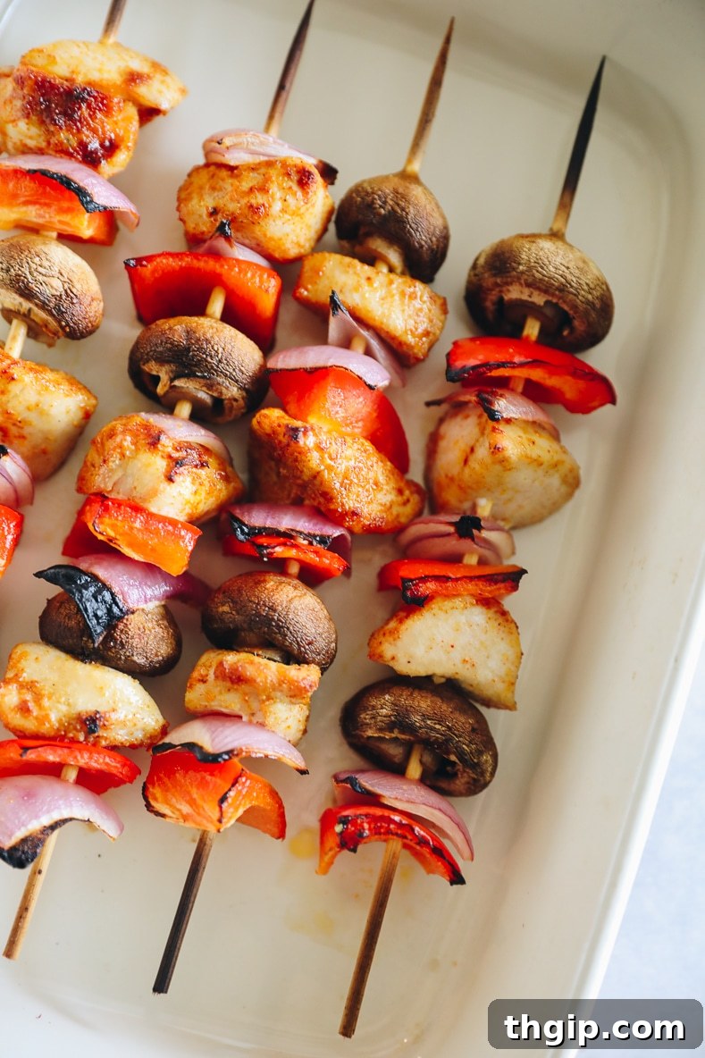 Golden Oven-Baked Chicken Skewers 6 Baked chicken kabobs with golden-brown edges on a baking sheet, fresh out of the oven.