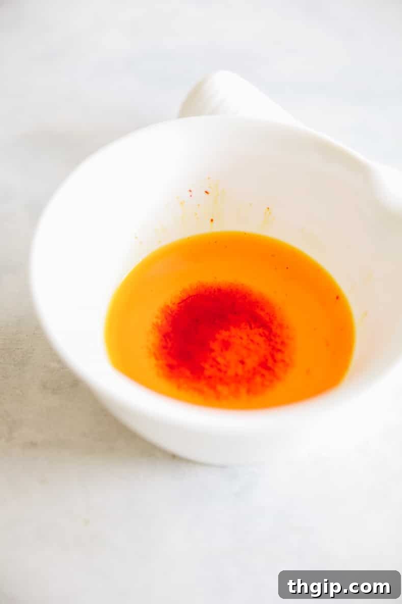 Fragrant Golden Saffron Rice 3 Ground saffron threads steeping in hot water in a mortar and pestle for rice preparation.